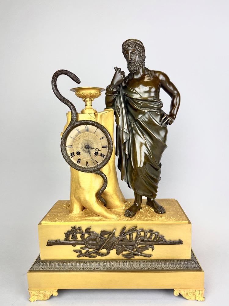 A 19thC. Empire ormolu and patinated bronze mantel clock representing Asclepius