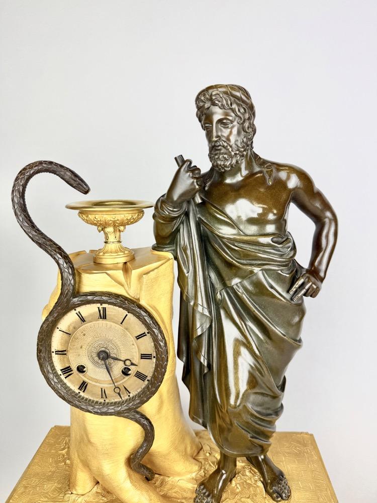 A 19thC. Empire ormolu and patinated bronze mantel clock representing Asclepius
