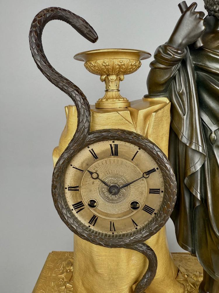 A 19thC. Empire ormolu and patinated bronze mantel clock representing Asclepius