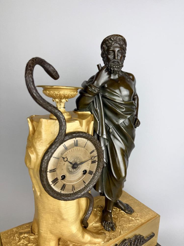 A 19thC. Empire ormolu and patinated bronze mantel clock representing Asclepius