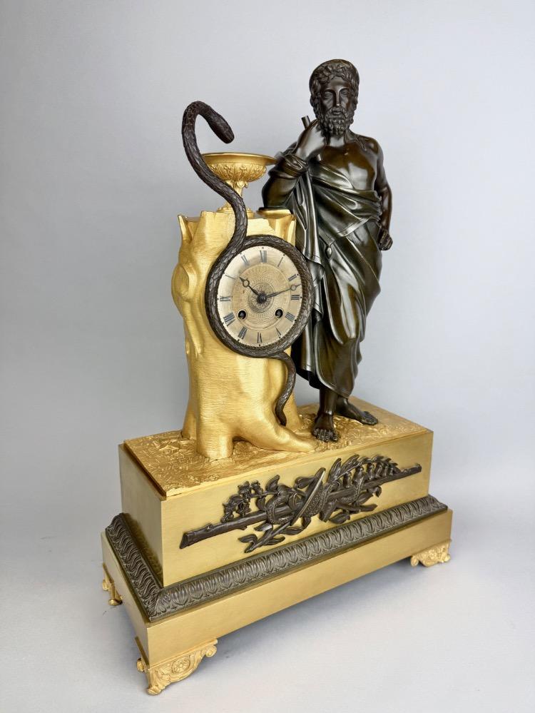 A 19thC. Empire ormolu and patinated bronze mantel clock representing Asclepius