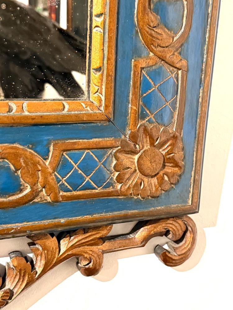 A carved and gilded wooden mirror. 