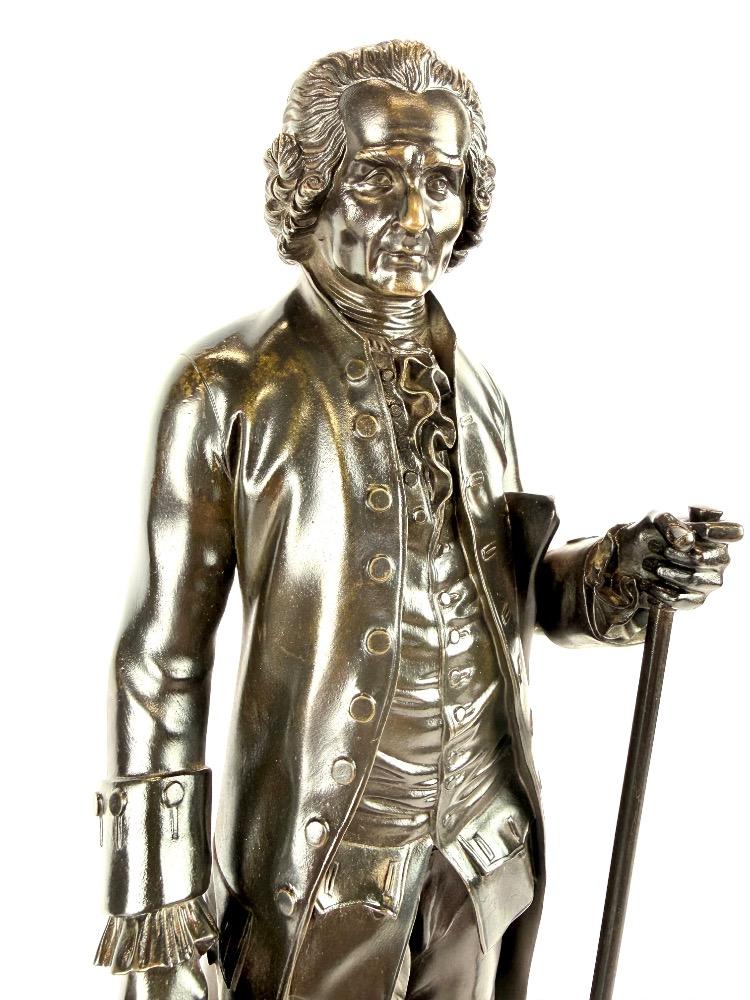 A pair of bronze sculptures of Voltaire and Rousseau.
